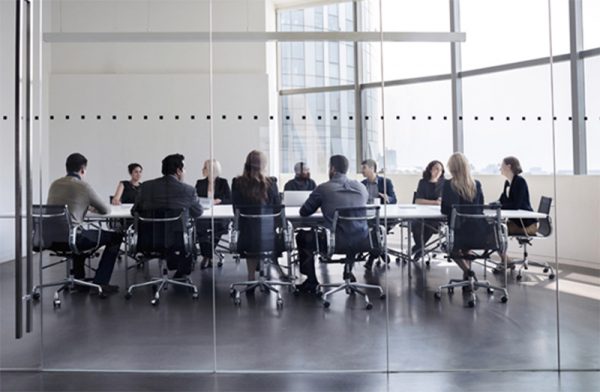 About Us | Group of businessmen and women having a meeting